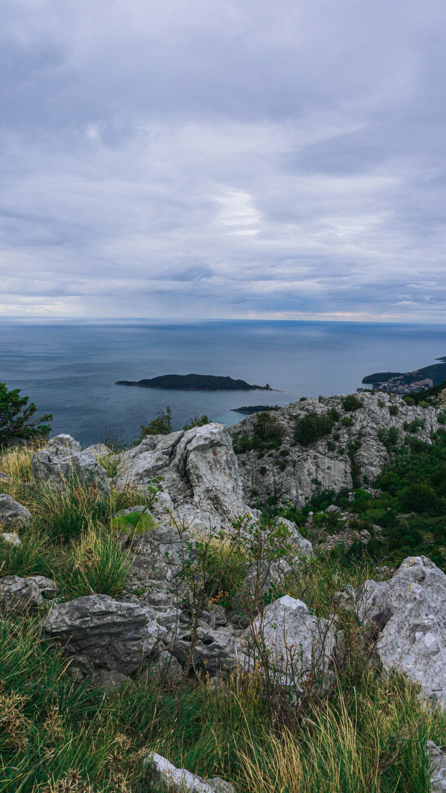 a bench sitting on top of a rocky hillside next to the ocean